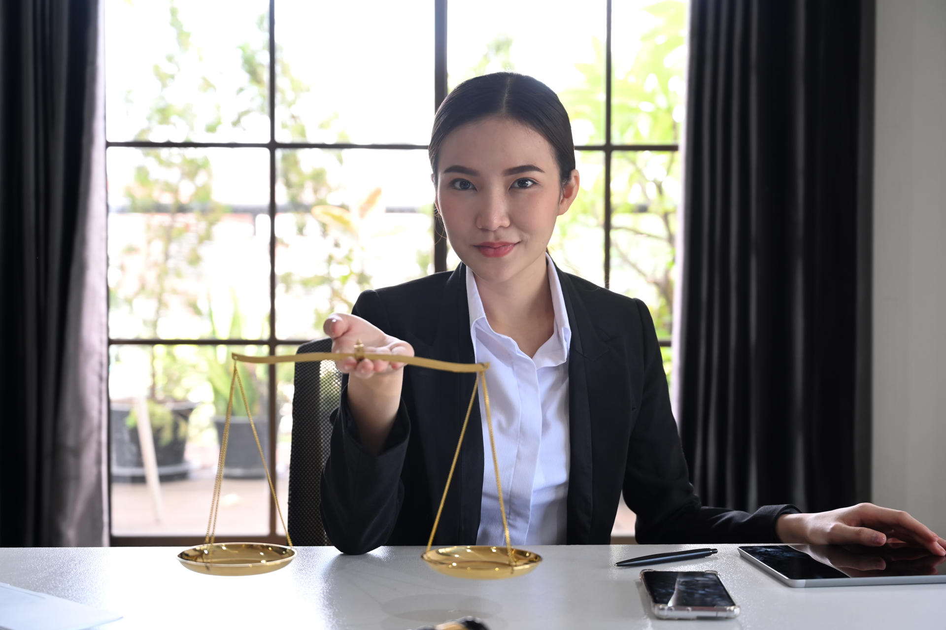 female-lawyers-holding-brass-scale-and-looking-con-2024-12-03-16-03-58-utc.jpg